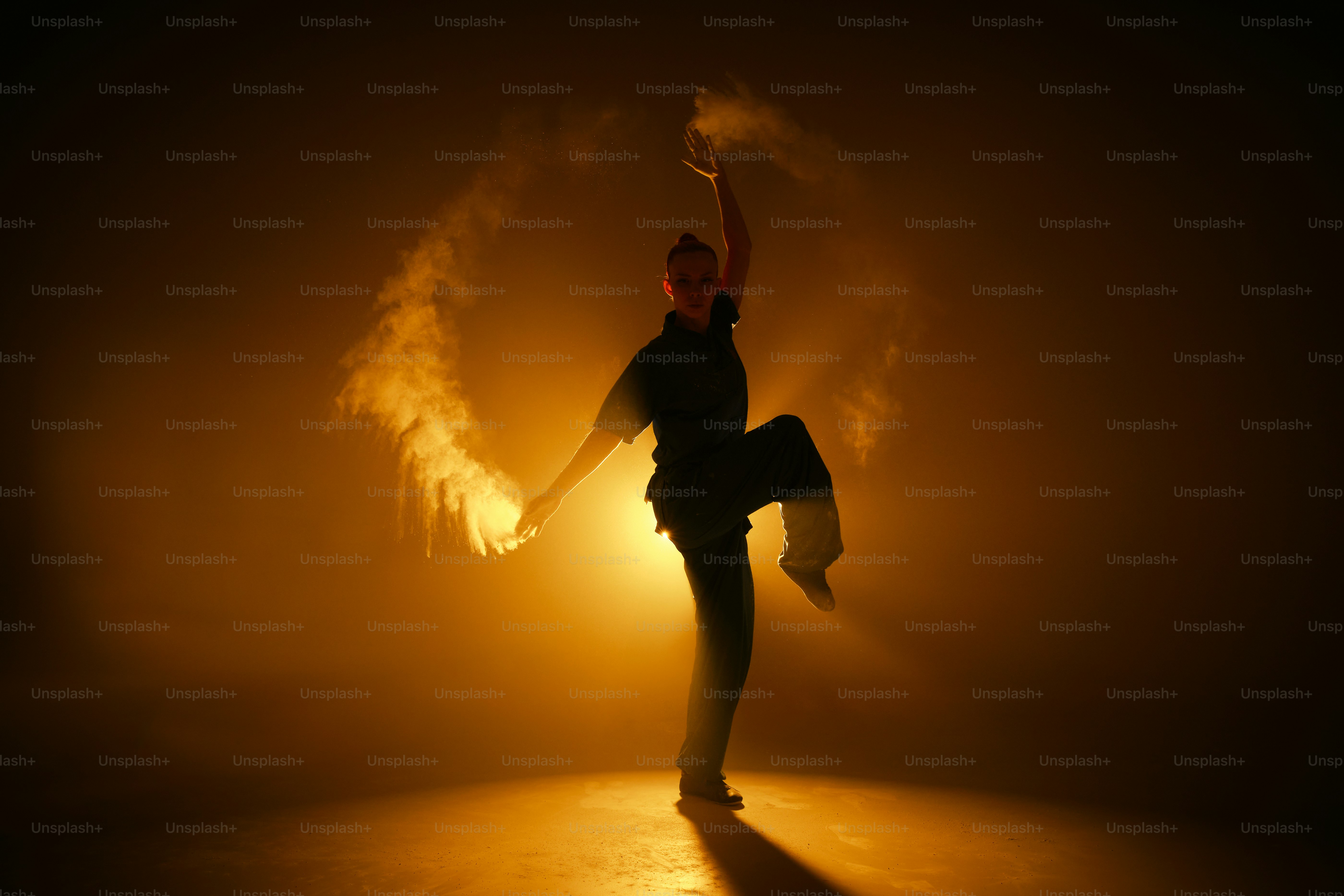 a person standing in the dark with their arms in the air