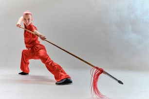 a man in red jumpsuit holding a broom