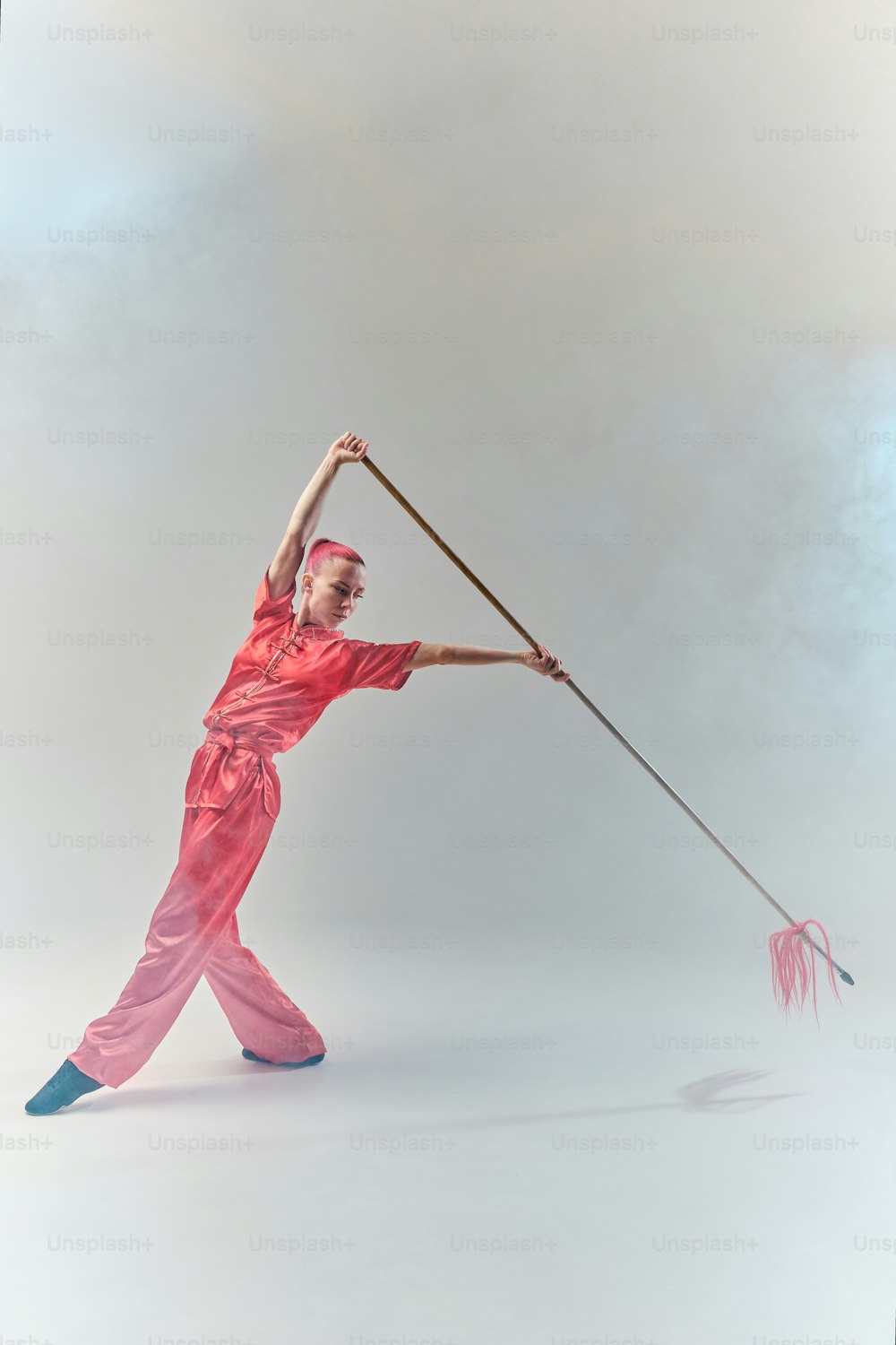 a man in a red outfit is holding a pole