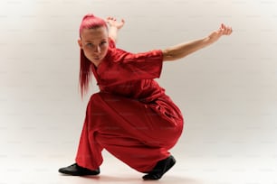 Une femme en tenue rouge fait un mouvement de danse
