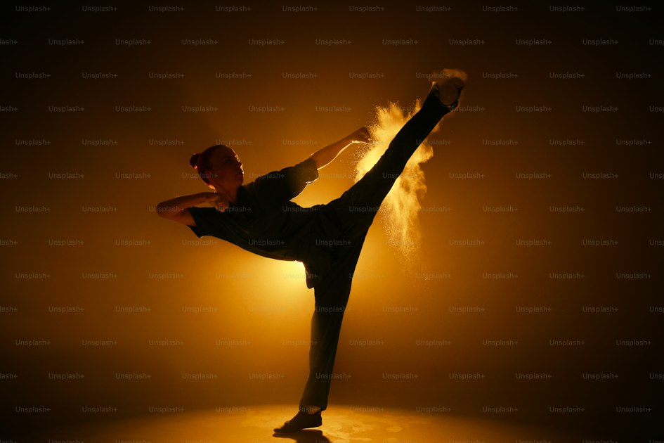 A figure in silhouette holding a martial arts stance against a dark background