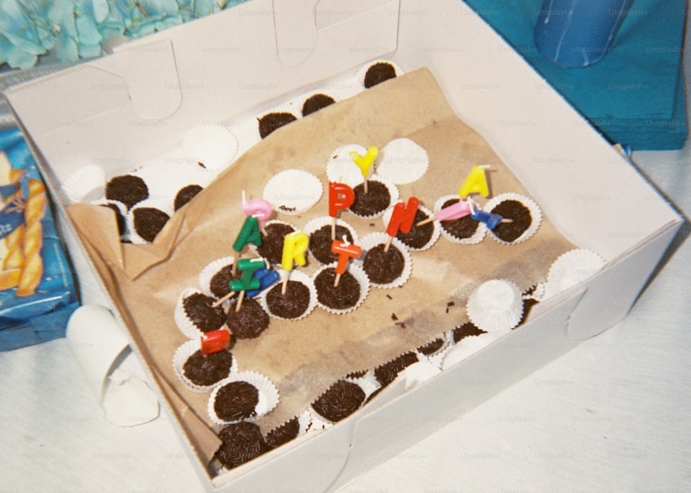 uma caixa de cupcakes com velas