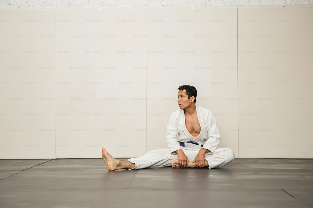 um homem sentado no chão com as pernas cruzadas
