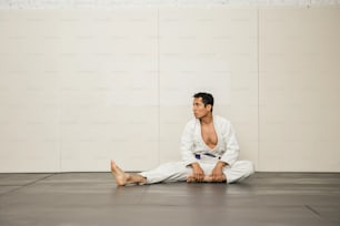 ein Mann, der mit gekreuzten Beinen auf dem Boden sitzt