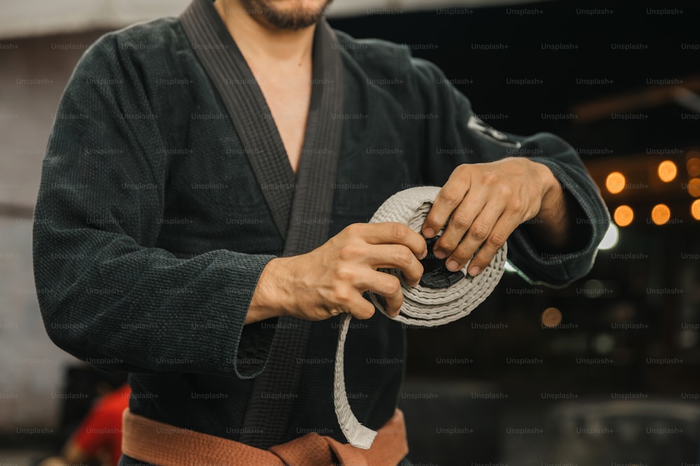 Un uomo in kimono tiene una corda