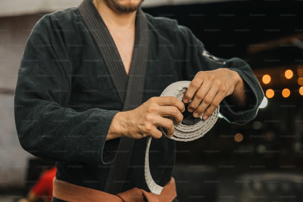 Ein Mann in einem Kimono hält ein Seil