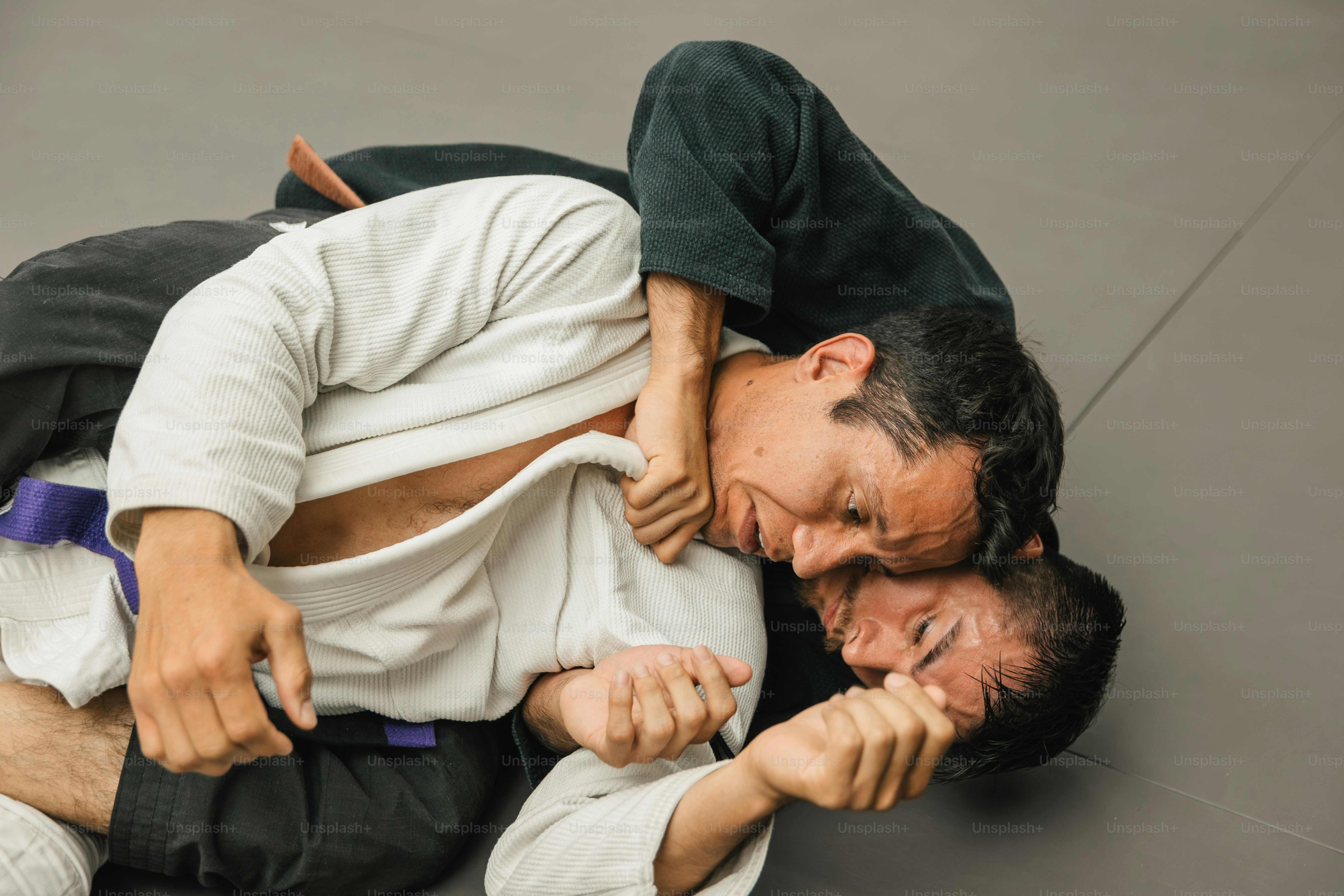 Zwei Männer in weißen Hemden und schwarzen Hosen ringen