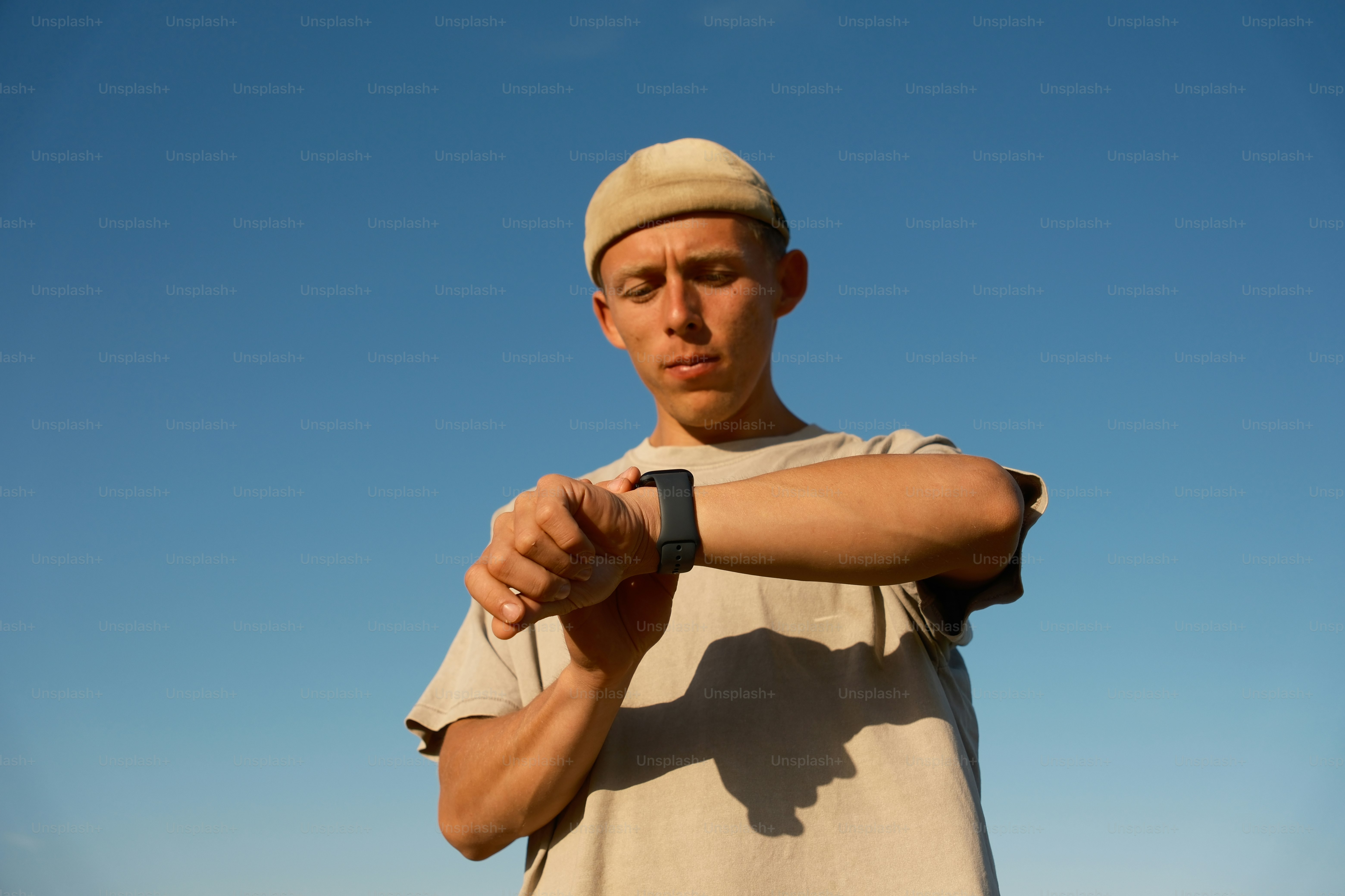 a man holding onto a smart watch with a sky background