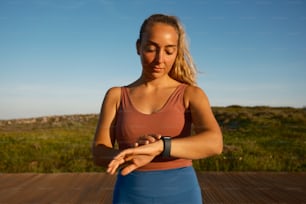 Una mujer con una camiseta sin mangas marrón está haciendo yoga