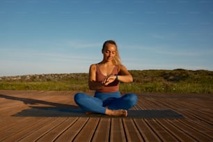 una mujer sentada en un suelo de madera en una postura de yoga