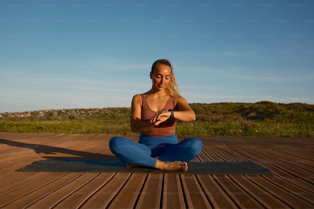 a woman sitting on a wooden floor in a yoga pose