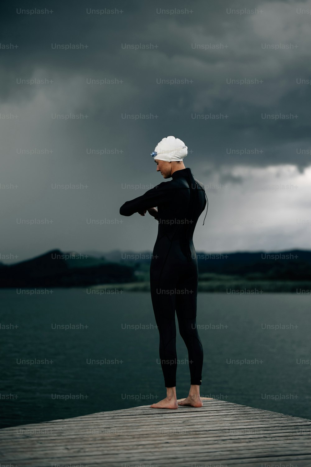 a woman in a wet suit standing on a dock
