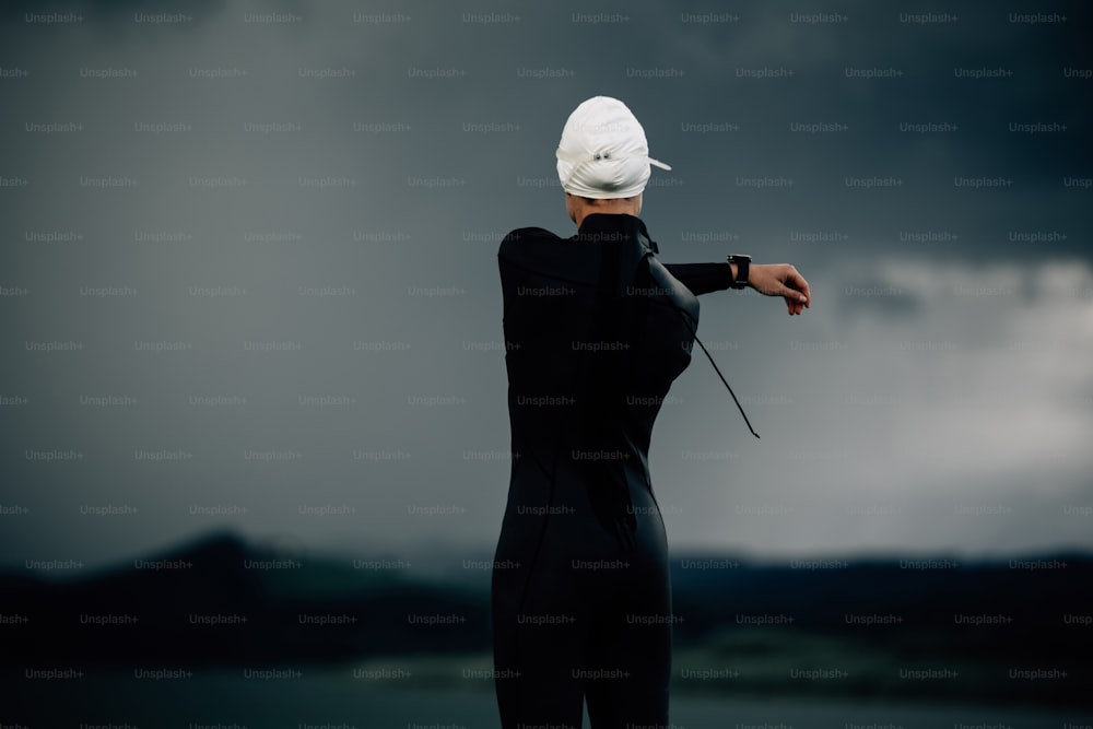 a woman in a wet suit and a white hat