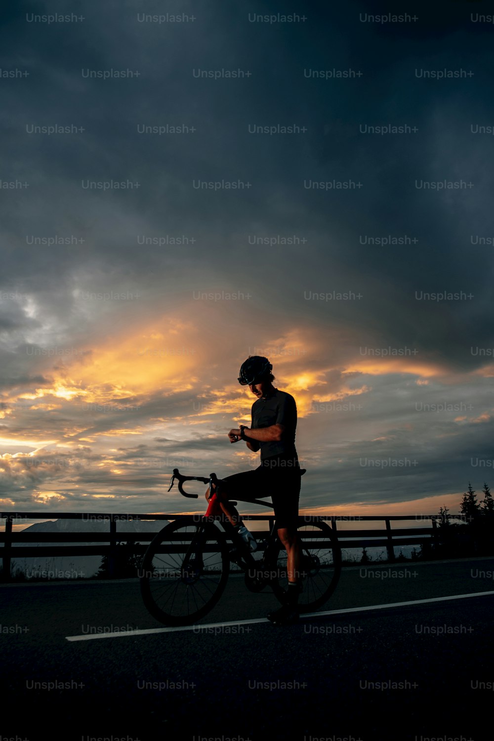 Un homme à vélo dans une rue sous un ciel nuageux