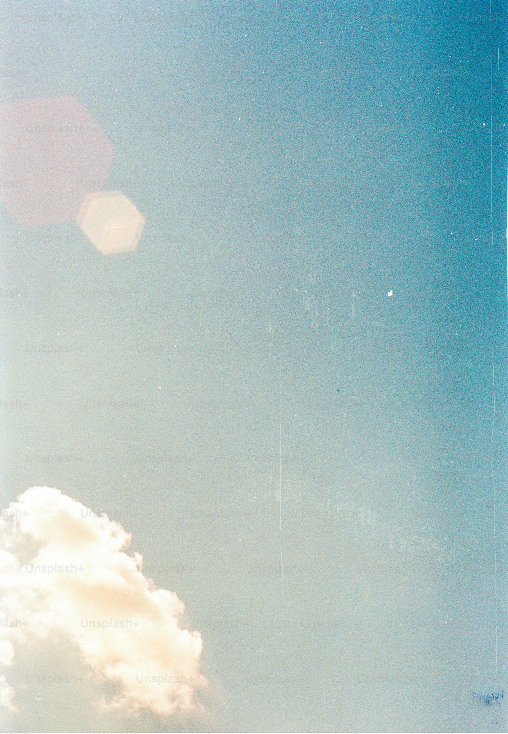 un avión volando a través de un cielo azul con nubes