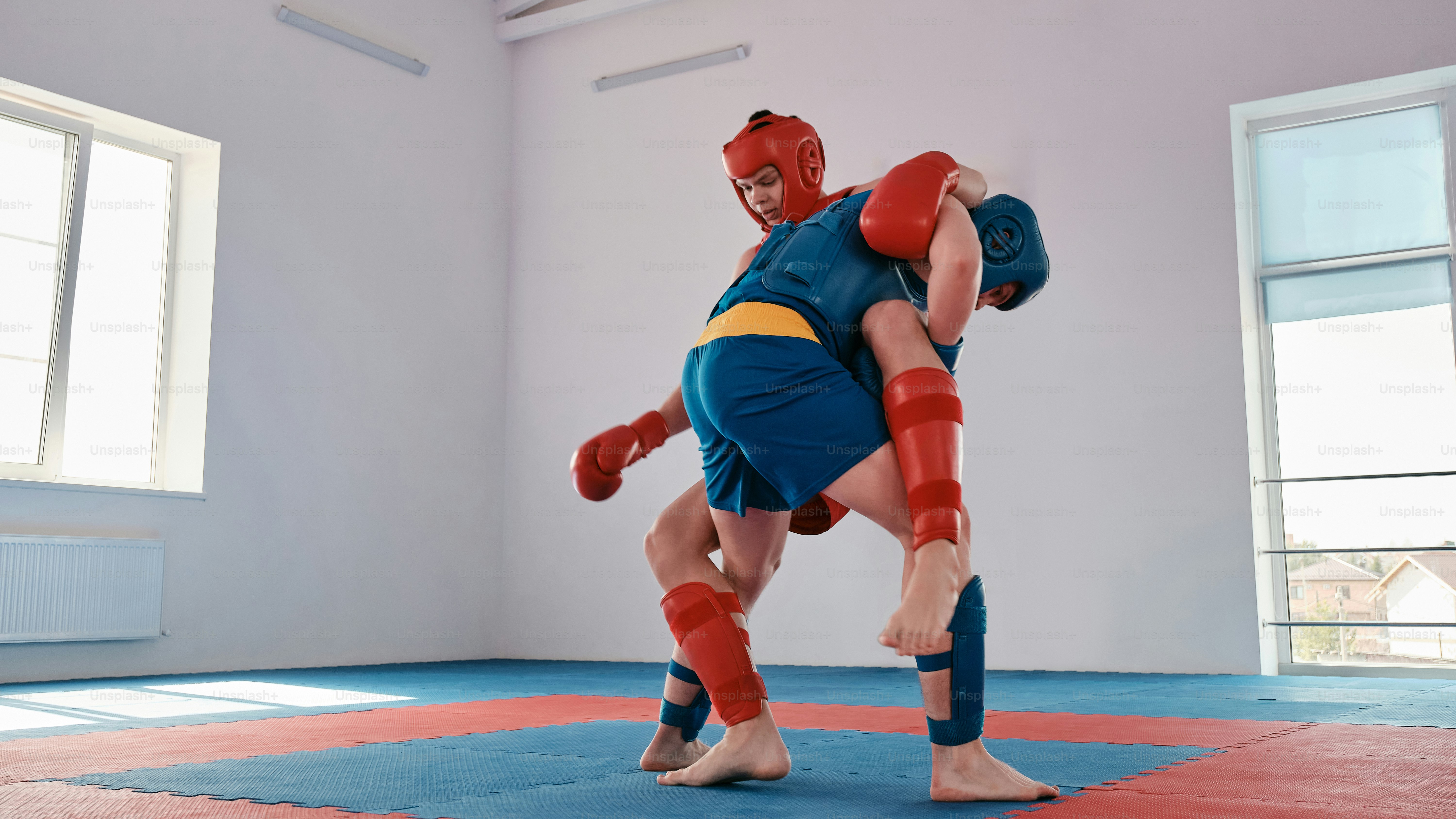 a man in a wrestling stance on a mat