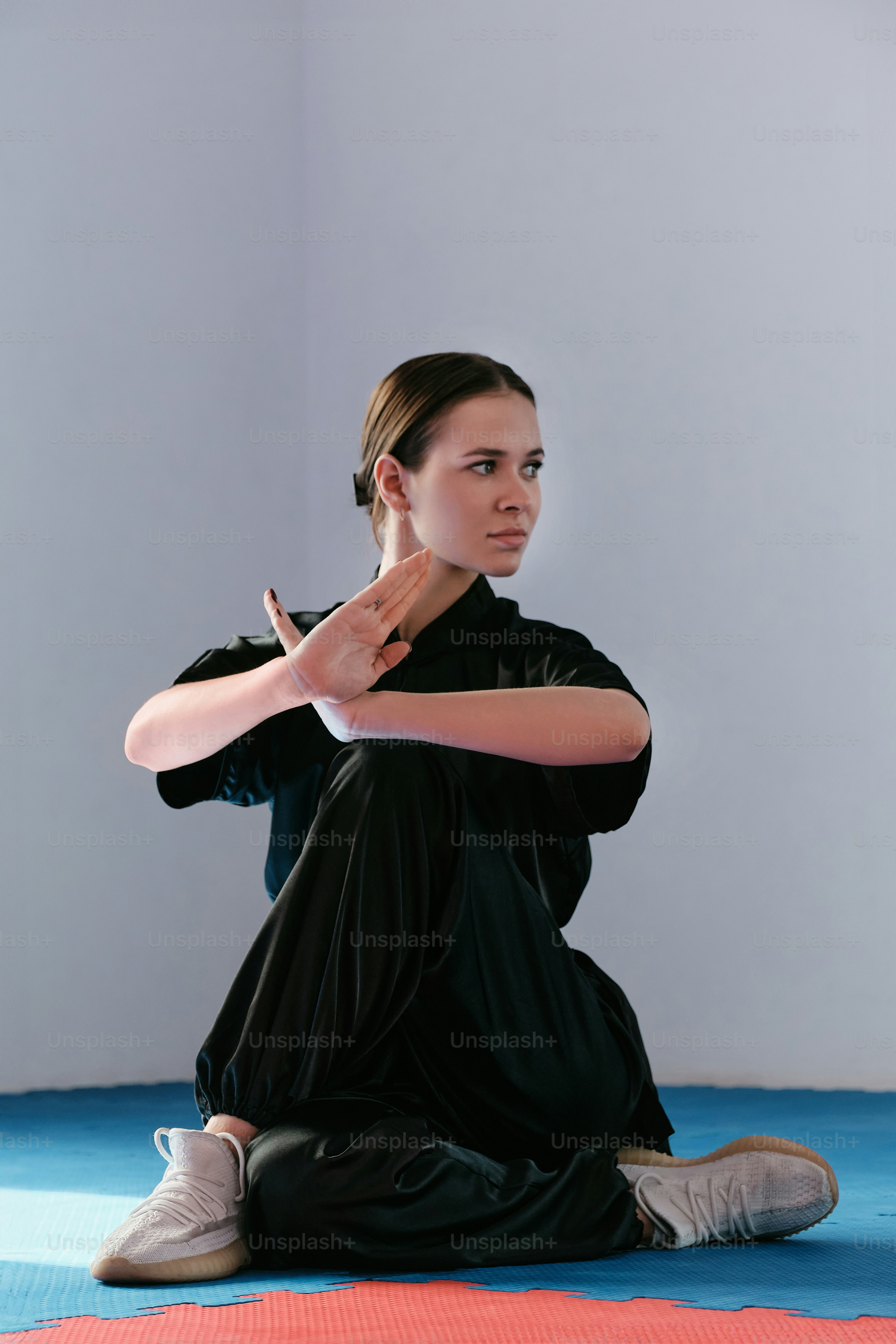 uma mulher sentada no chão fazendo uma pose de ioga