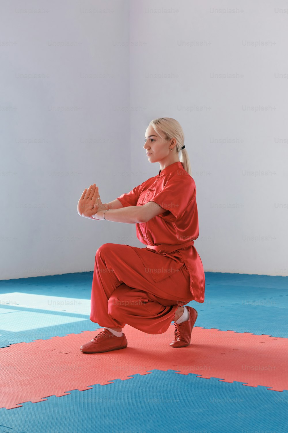 a woman in a red outfit doing a yoga pose