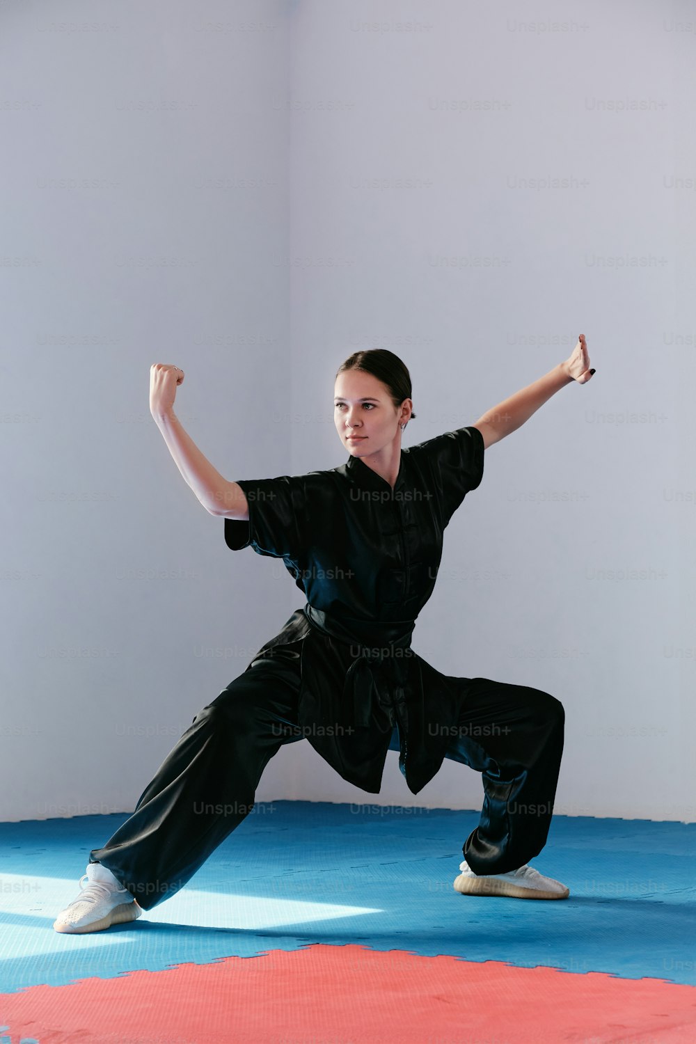 Una mujer con una camisa negra está haciendo una pose de karate
