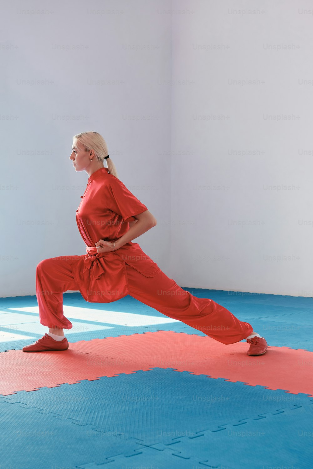 a woman in a red outfit is doing a yoga pose