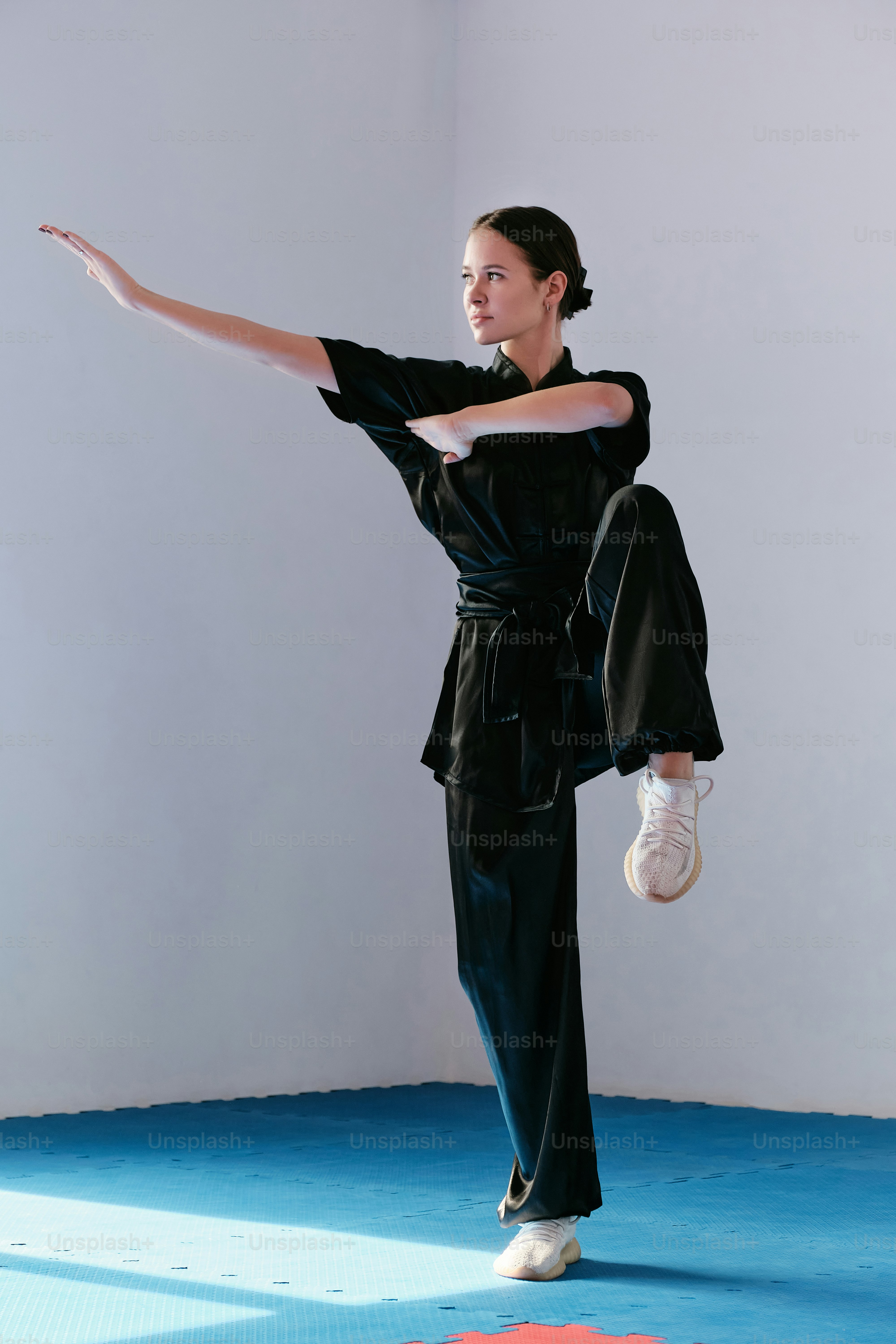 uma mulher com uma roupa preta está fazendo um movimento de dança
