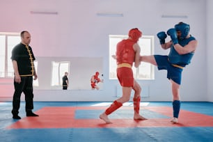 a man in a red and blue outfit kicking another man in a red and blue
