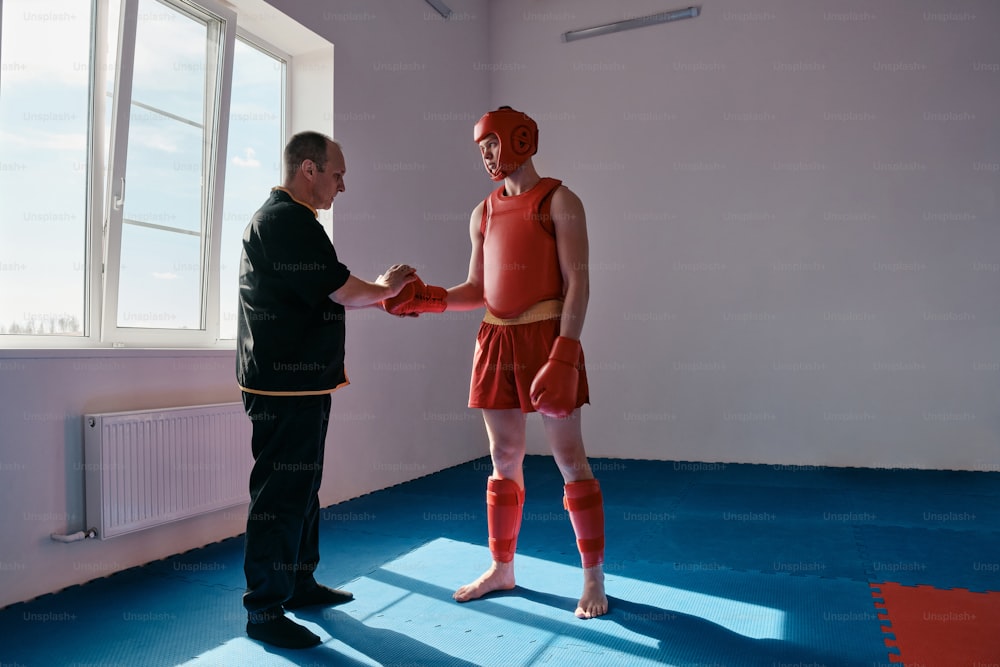 a man in a red uniform is shaking hands with a man in a black suit