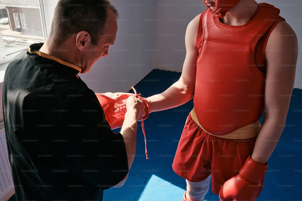 a man wearing boxing gloves is being fitted