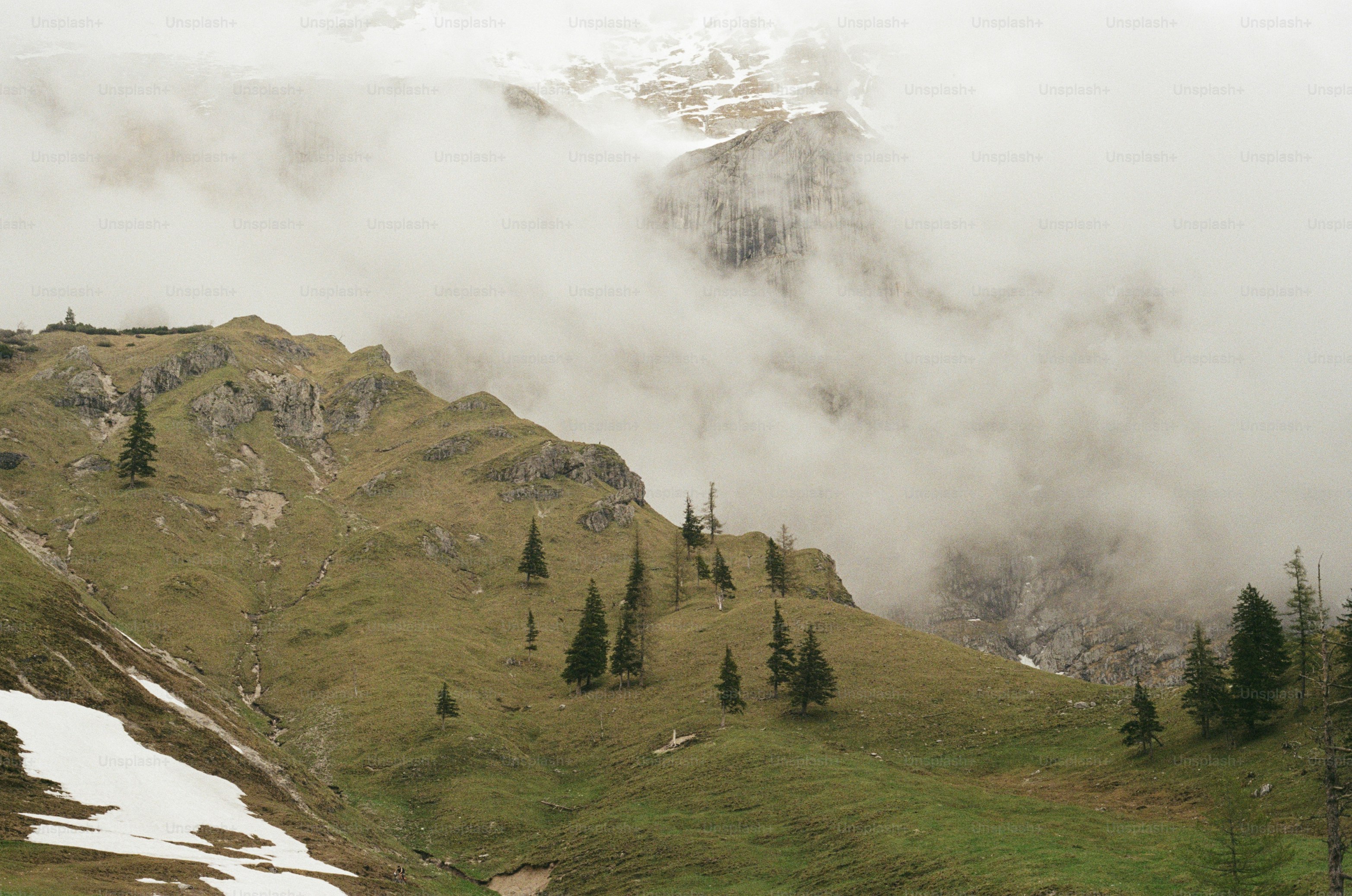 una montaña cubierta de nubes y árboles en un día nublado