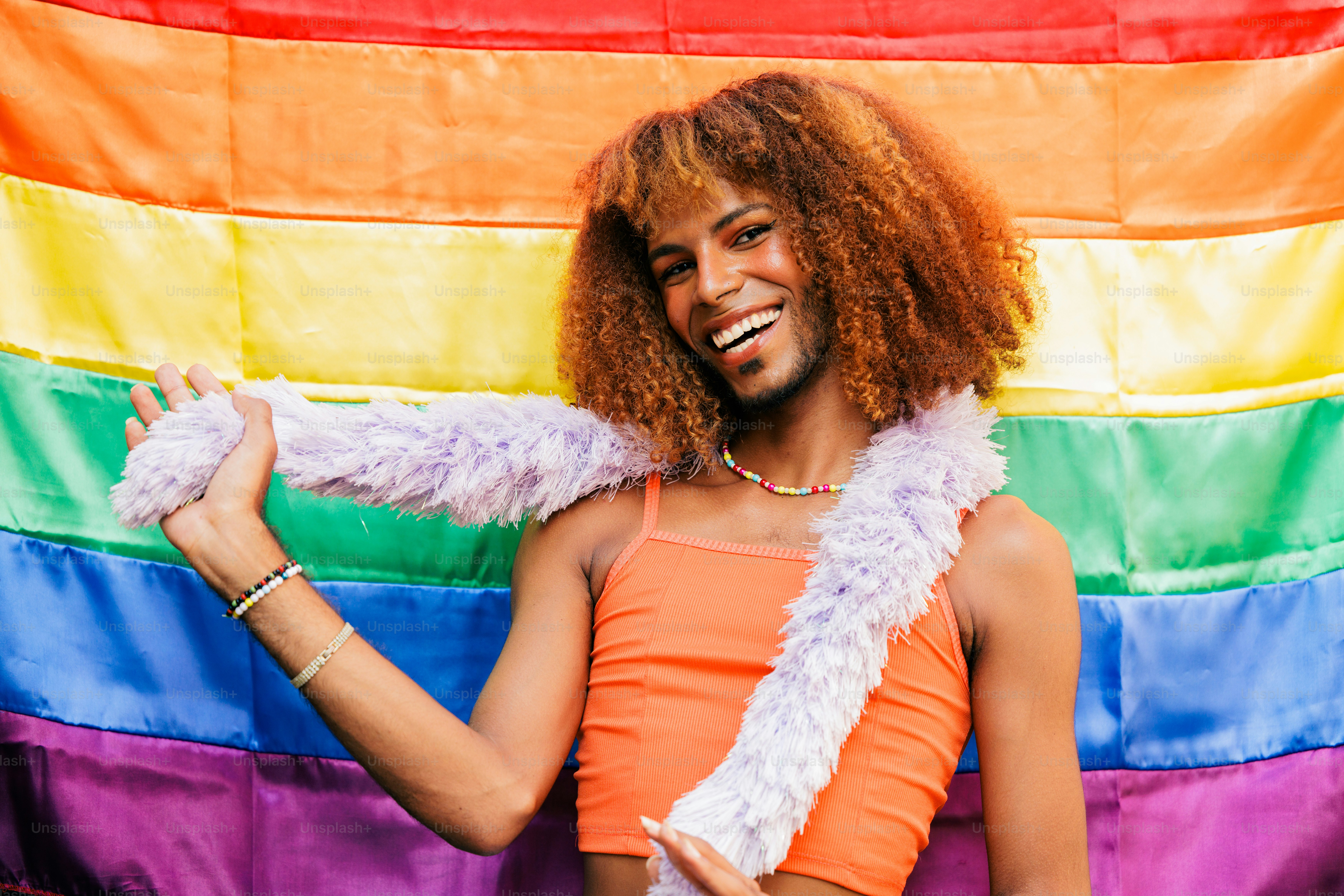 a man with a rainbow flag in the background