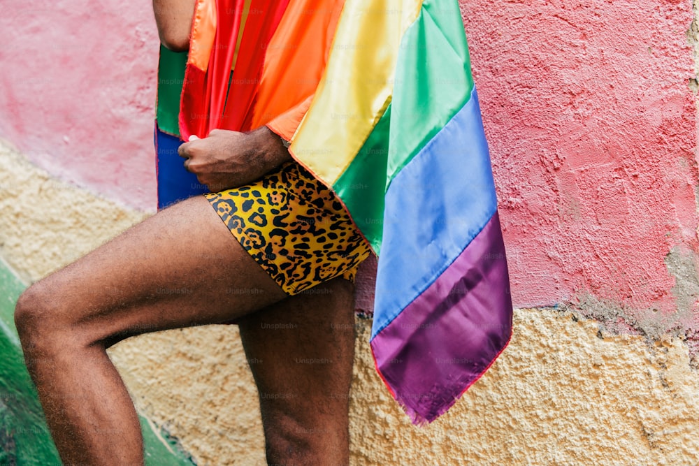 a man with a rainbow shirt and leopard print shorts