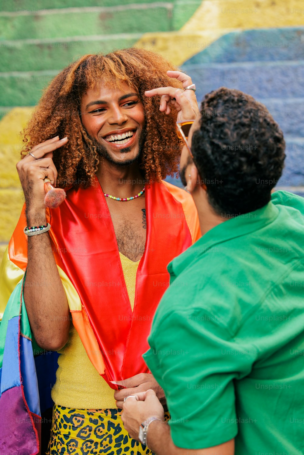 a man in a red vest and a man in a green shirt