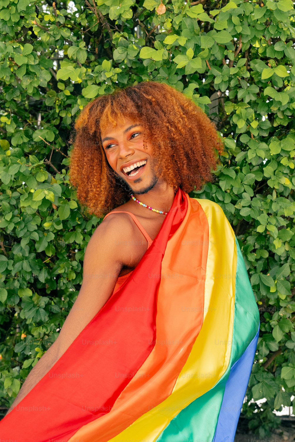 un uomo con i capelli rossi e una bandiera arcobaleno