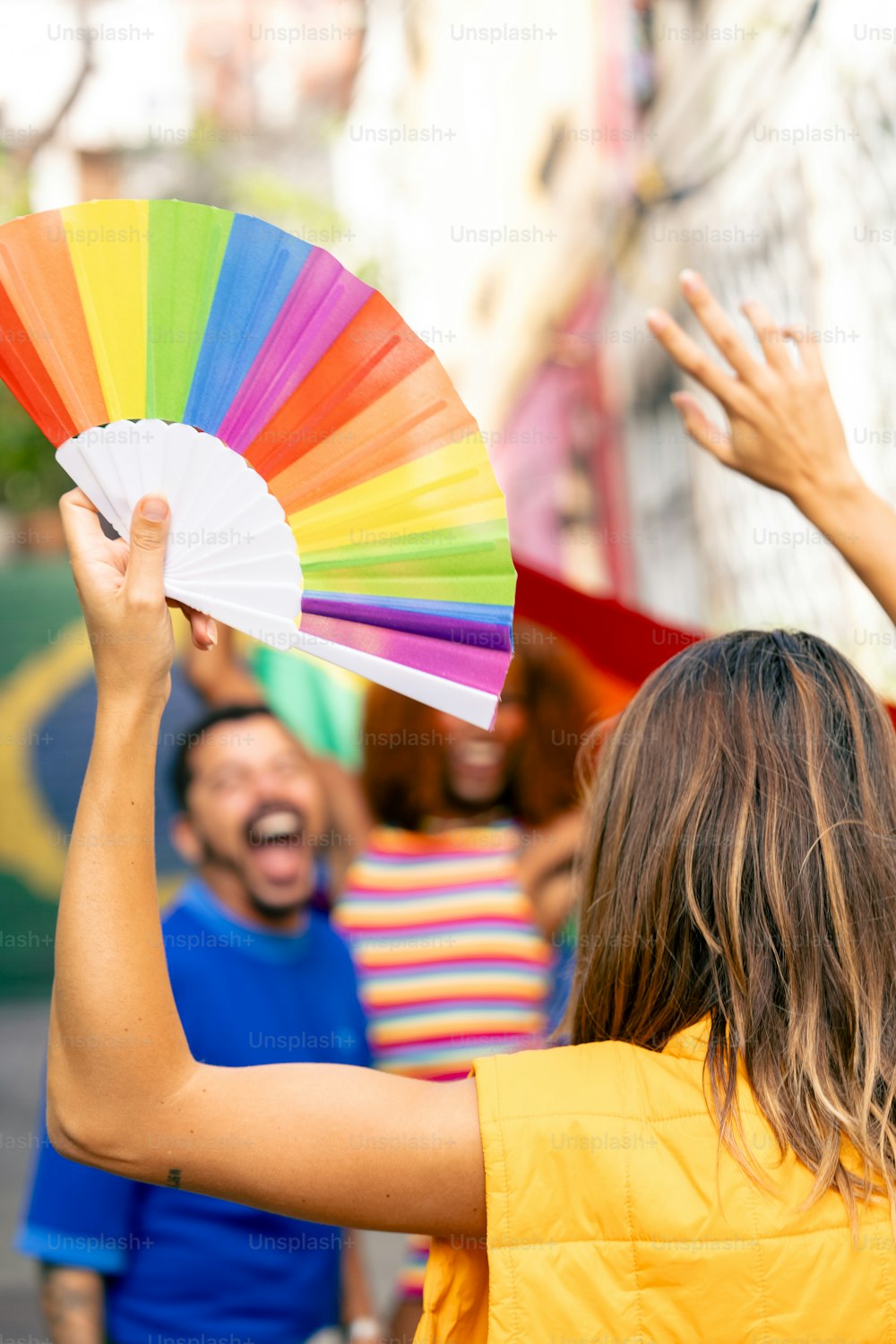 a woman holding a colorful fan in front of a group of people