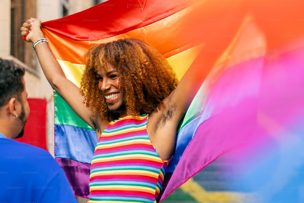 a woman holding a rainbow flag in her hands