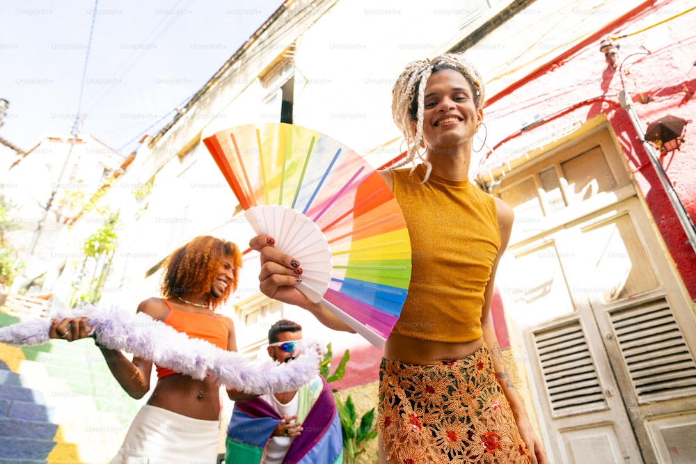 a woman holding a colorful fan next to another woman