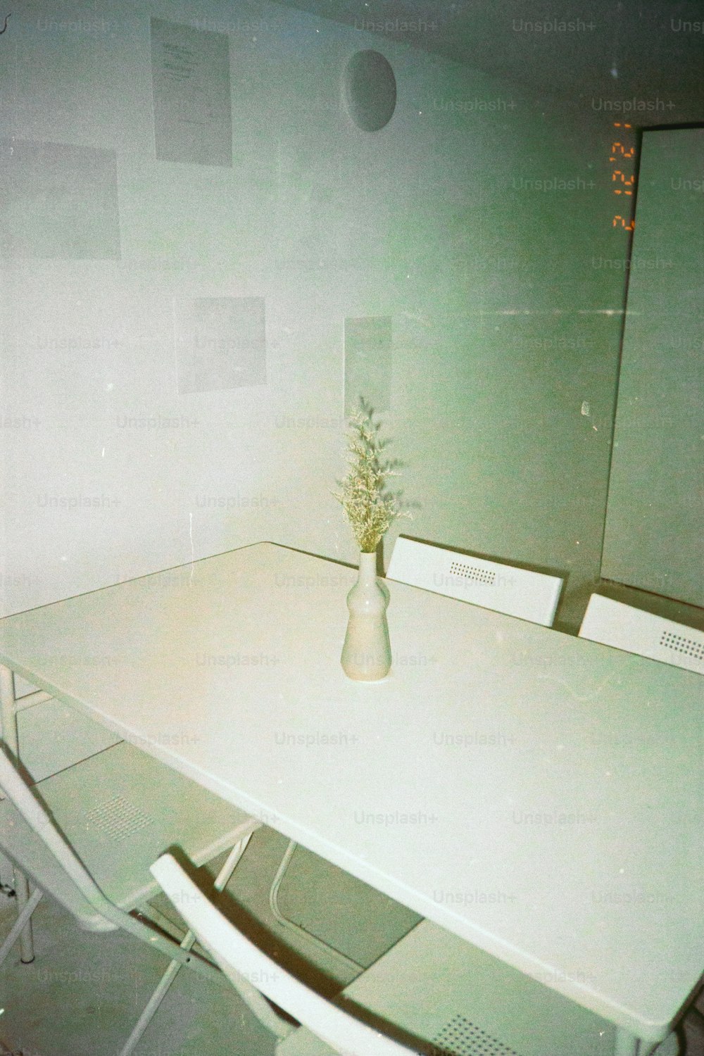 a white table with a vase of flowers on it