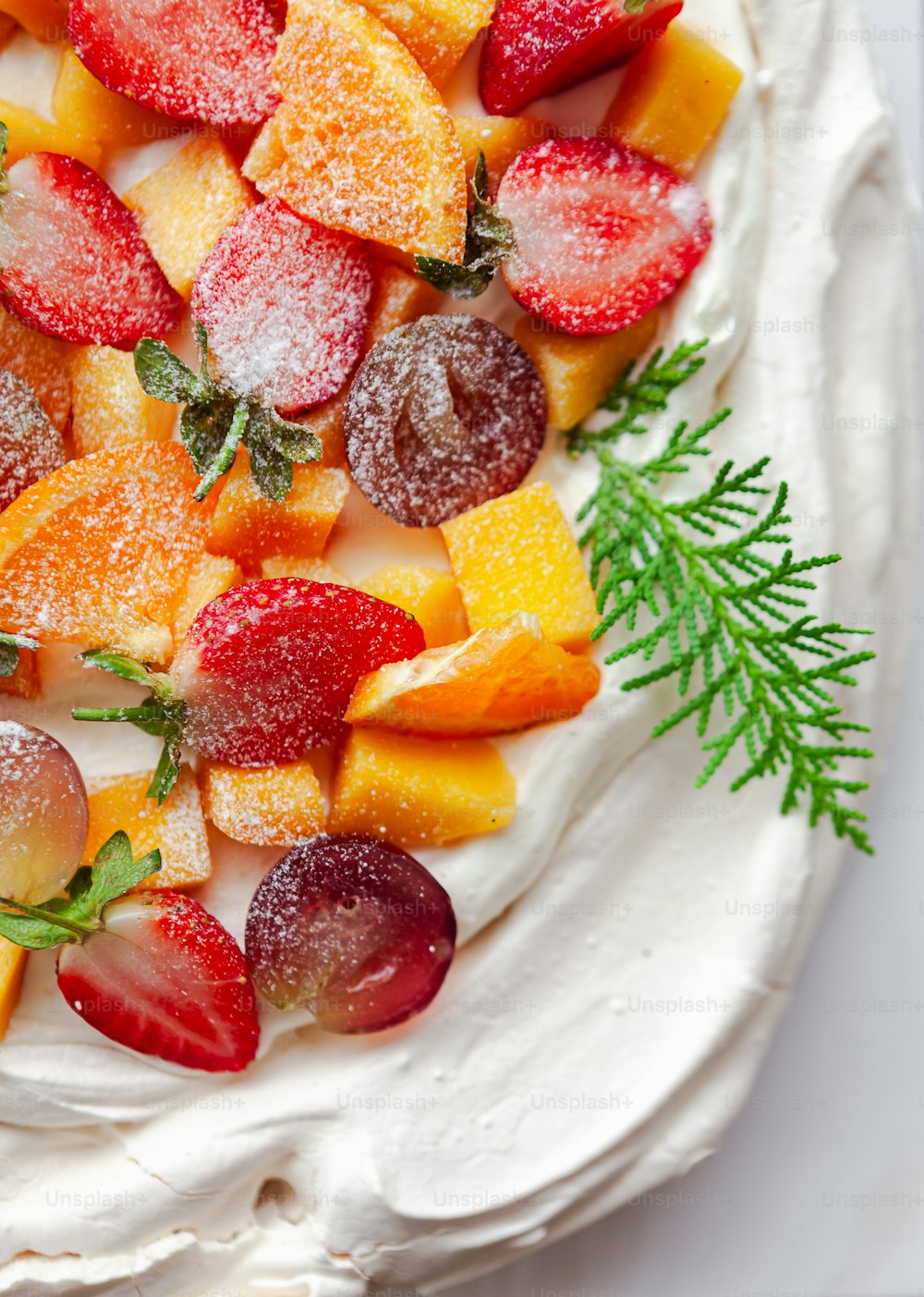 a white plate topped with a cake covered in fruit