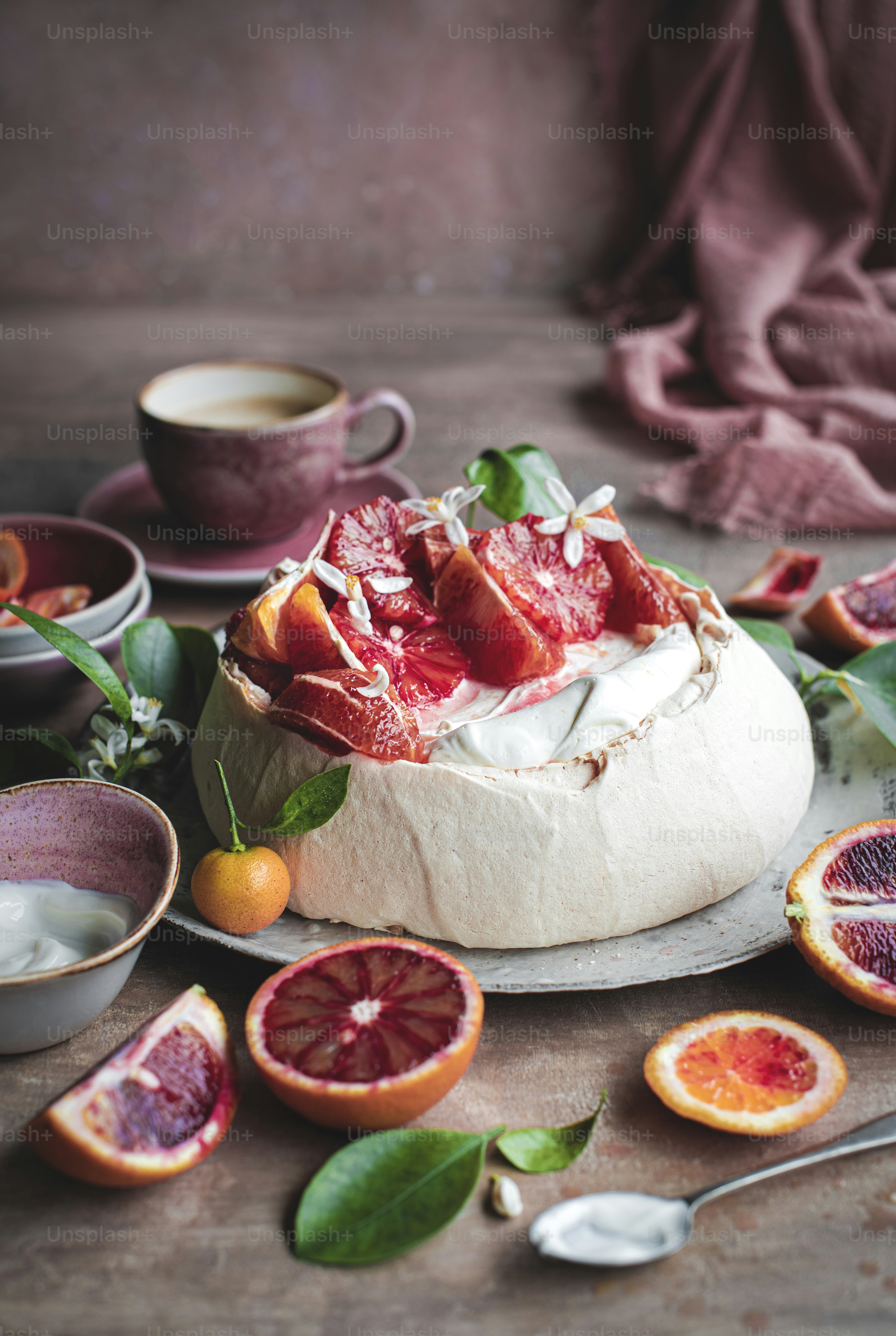 a table topped with a cake covered in fruit