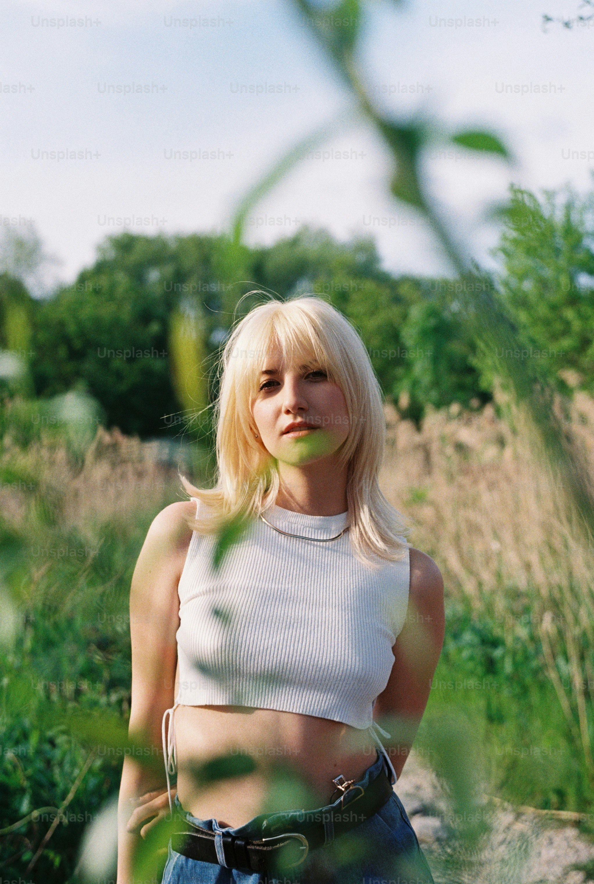 a woman with blonde hair standing in a field