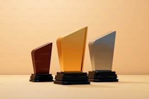 una fila de tres trofeos colocados encima de una mesa