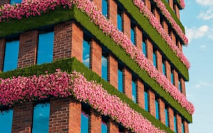 un edificio con flores rosadas que crecen a un lado