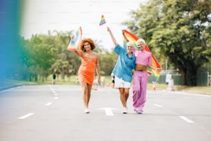 a group of women walking down a street holding kites