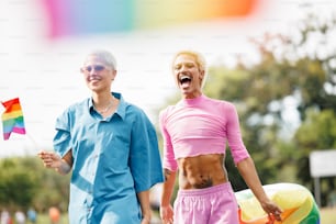 a man and a woman holding a rainbow kite