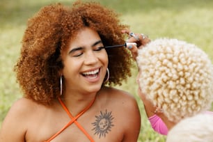 a woman smiles as she brushes her afro hair