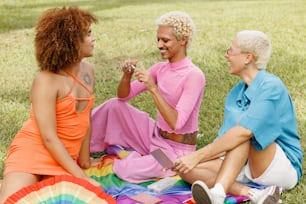 a group of women sitting on top of a grass covered field