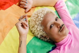 a man laying on top of a rainbow colored blanket