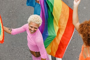 a woman in a pink shirt holding a rainbow flag