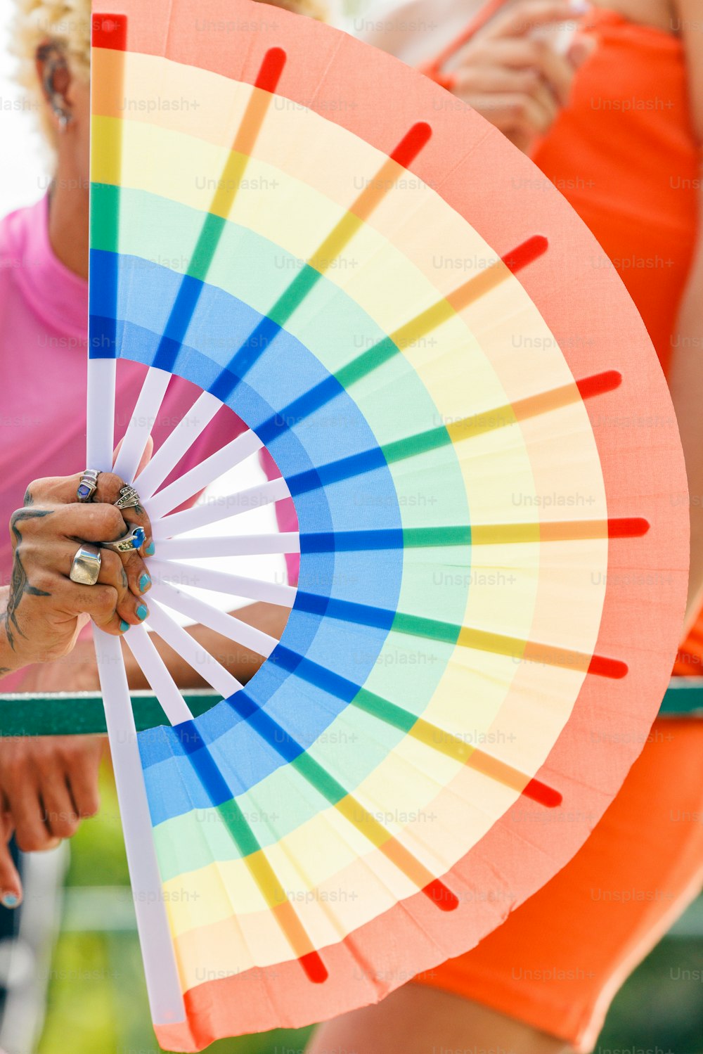 uma mulher segurando um guarda-sol colorido em sua mão