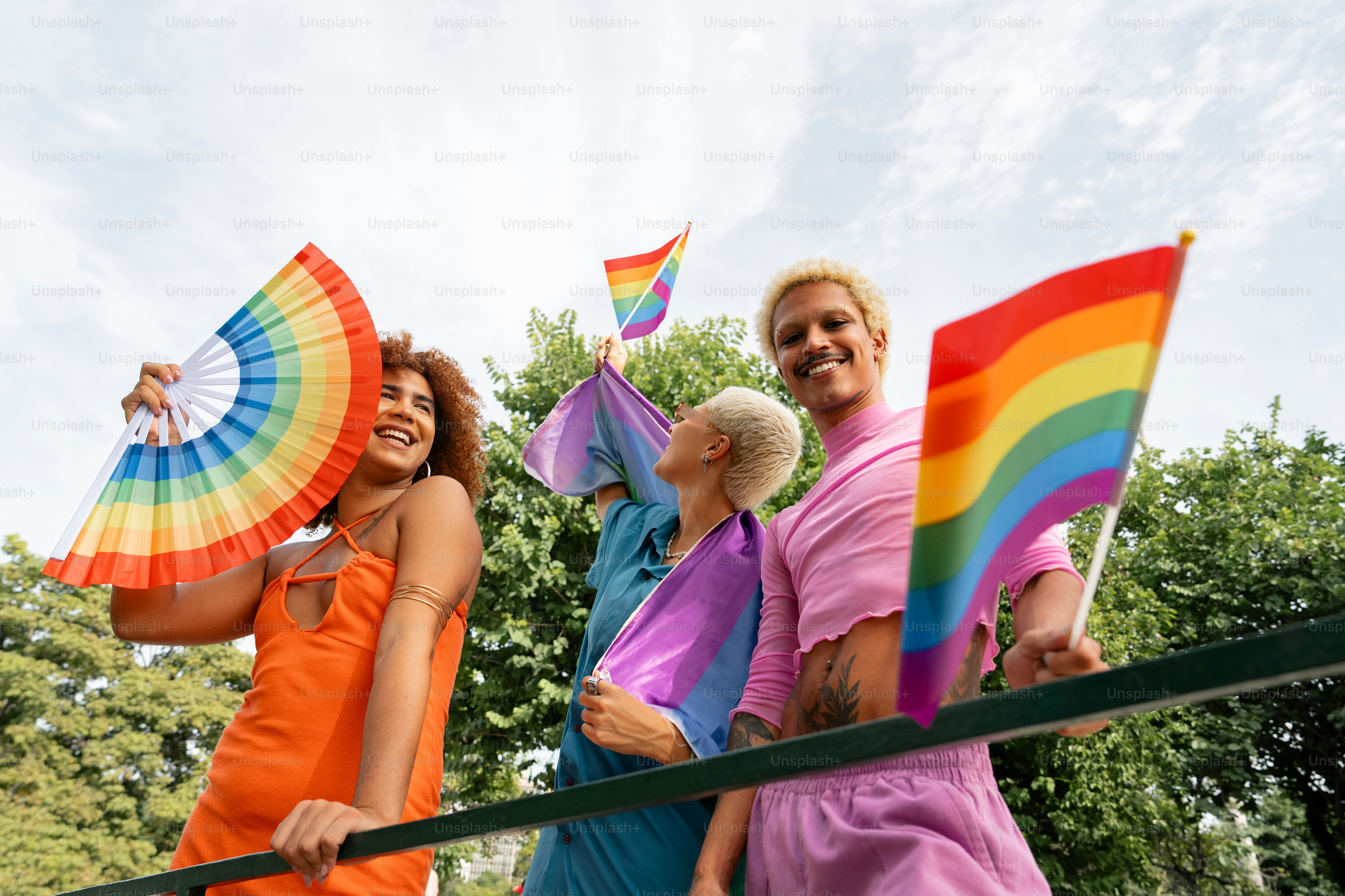 a group of people standing next to each other holding rainbow umbrellas